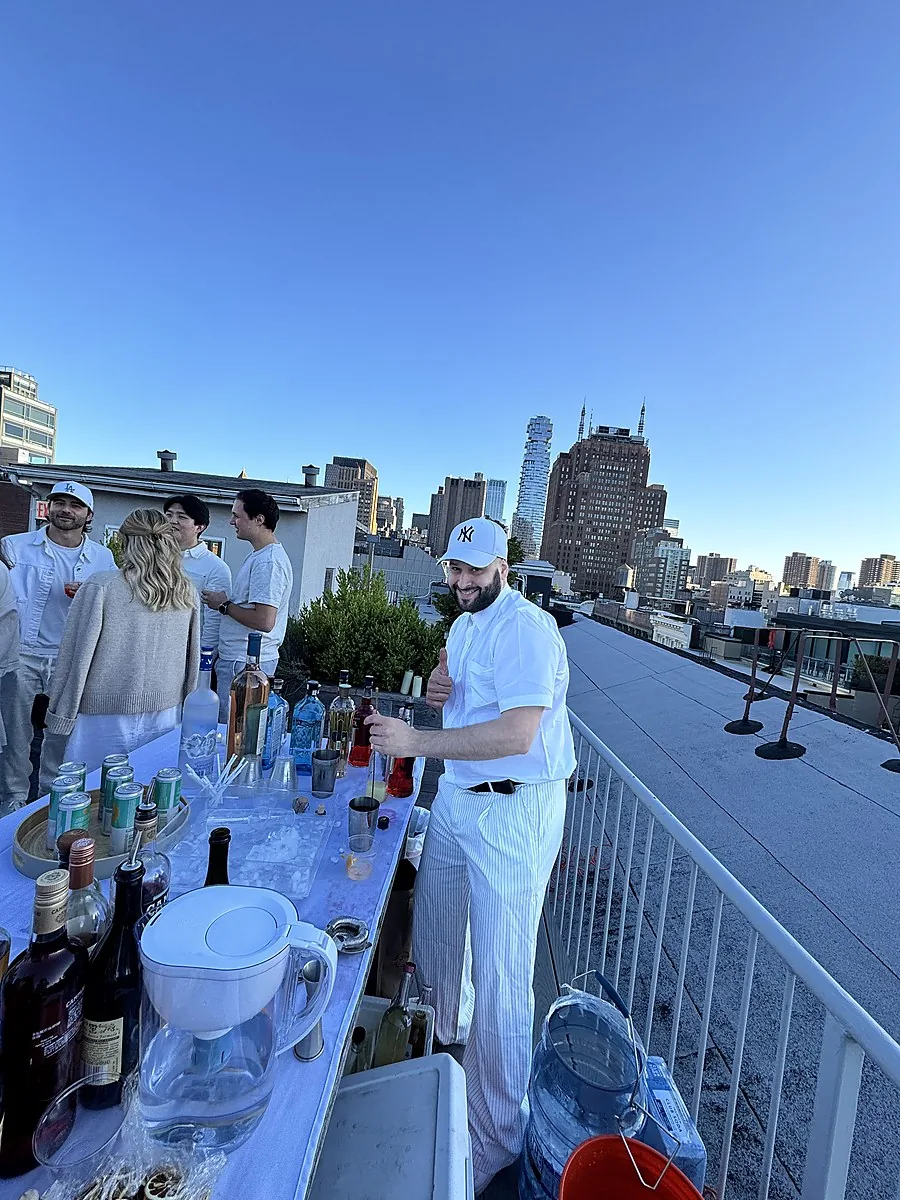 Luxe & Libations rooftop bar setup with guests and the Manhattan skyline